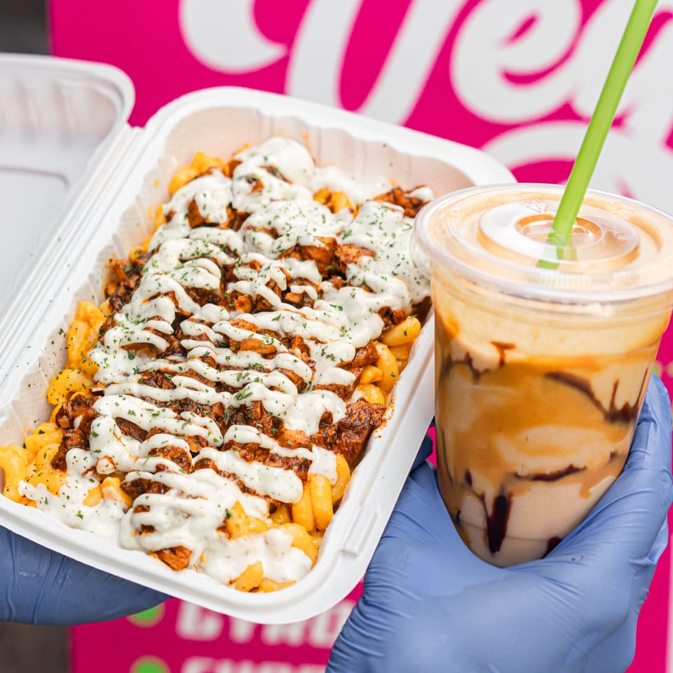 Vegan mac and cheese topped with plant-based meat and white sauce, next to a vegan milkshake.